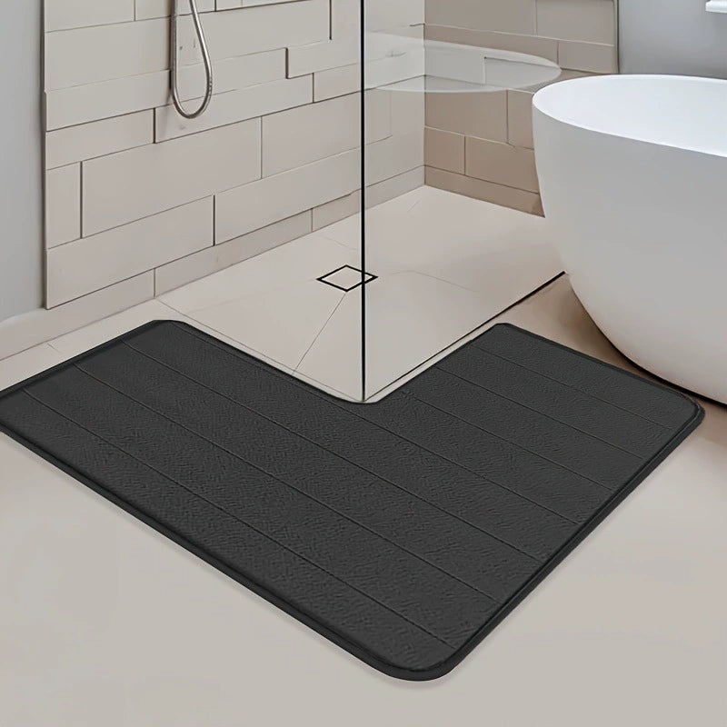 Gray bath mat in a bathroom setting with a shower and bathtub.