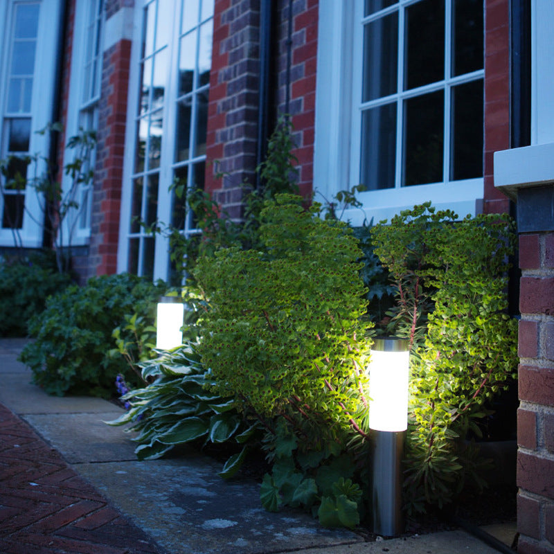 Outdoor garden scene with illuminated solar lights near a brick building