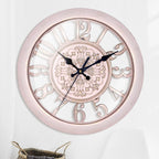 Decorative wall clock with rose gold frame and black hands on a light gray background