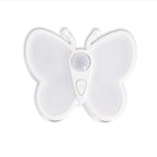 A white butterfly-shaped motion sensor night light with a central circular sensor and a small button marked with an 'M', shown on a plain white background.