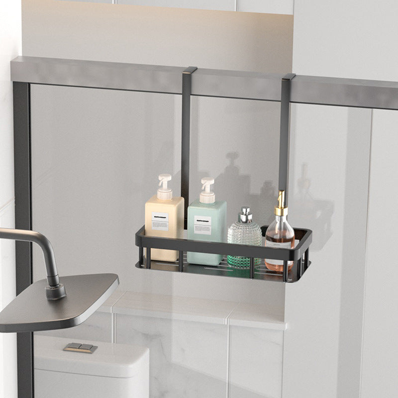Bathroom shelf with toiletries against a glass shower wall