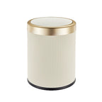 Round trash can with ribbed design and gold rim on a white background