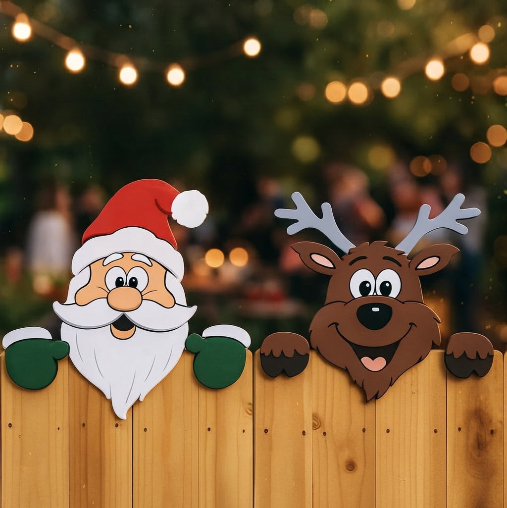 A festive holiday decoration set featuring a Santa Claus head with a red hat and white beard peeking over a wooden fence, alongside a brown reindeer with gray antlers. The background shows a blurred outdoor scene with warm string lights and bokeh.