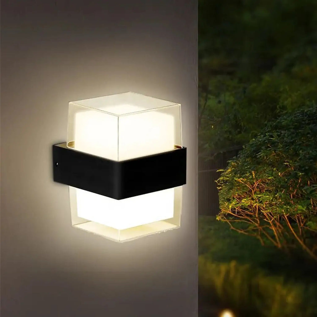 Modern outdoor wall light fixture on a neutral background with a second image of it in a garden setting.