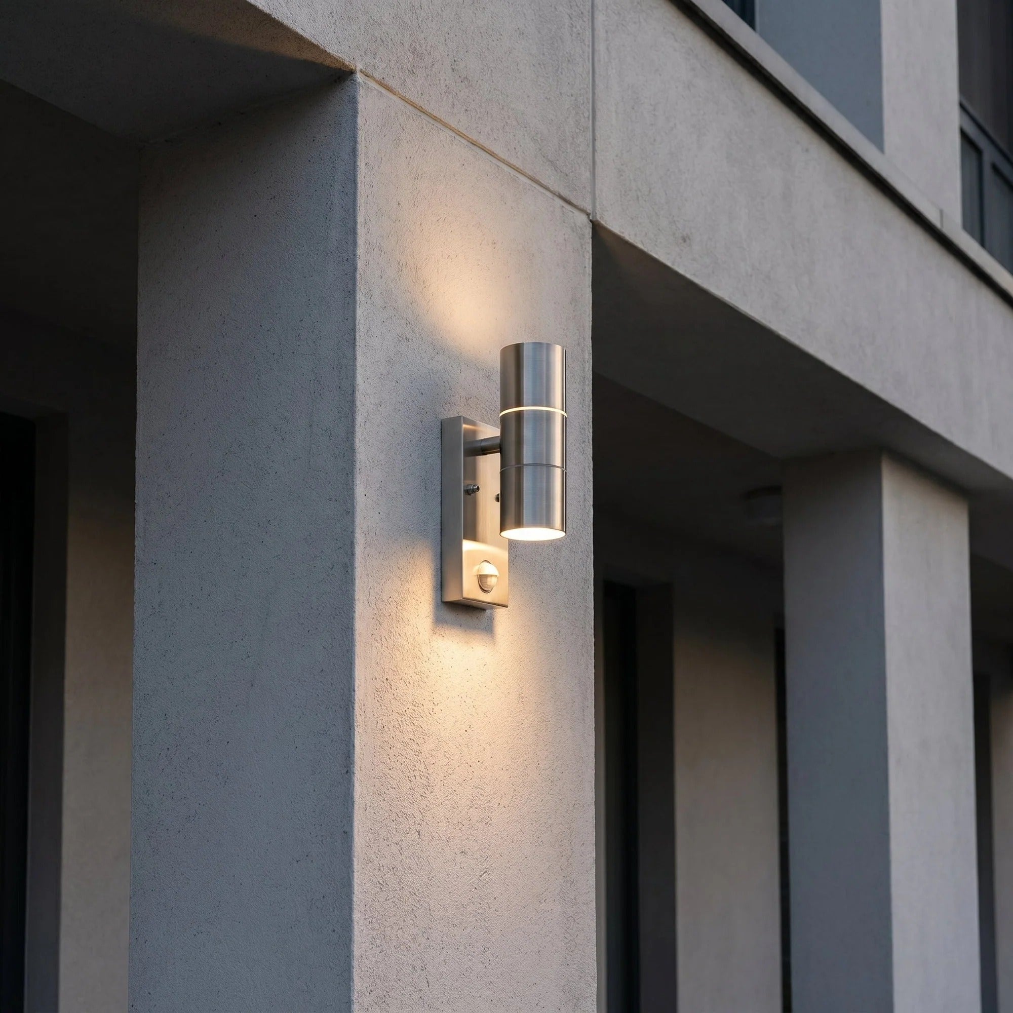 Modern outdoor wall light fixture on a concrete building exterior.