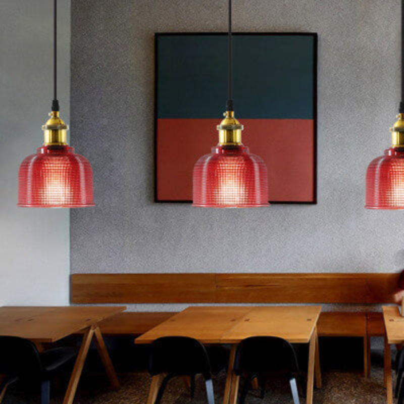 Modern interior with red pendant lights, wooden tables, and black chairs.