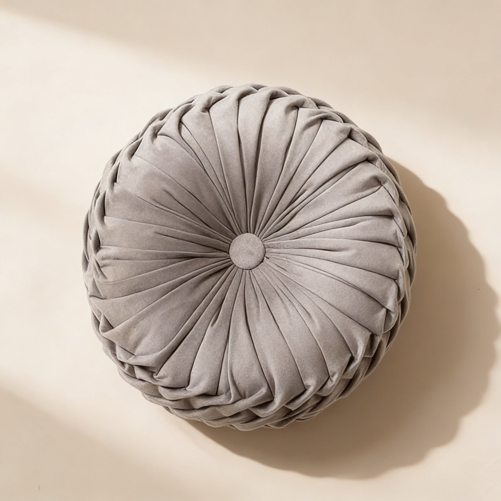 Round pleated cushion on a beige background