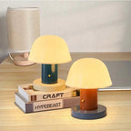 Two small table lamps on a surface with a guitar and cat in the background.