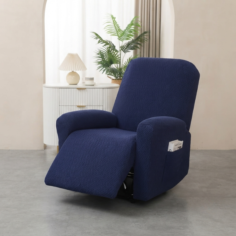 A navy blue upholstered recliner chair shown in a softly lit room with a white sideboard, lamp, curtain, and potted plant in the background.