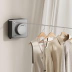 Wall-mounted clothesline system with hangers and clothes in a neutral setting