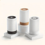 Three textured cylindrical devices on white stands against a beige background
