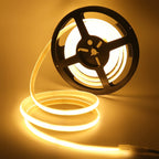 Spool of LED strip light with warm glow on a beige background