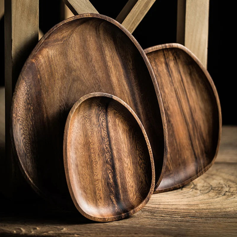 Set of wooden trays with a rustic finish on a wooden surface.