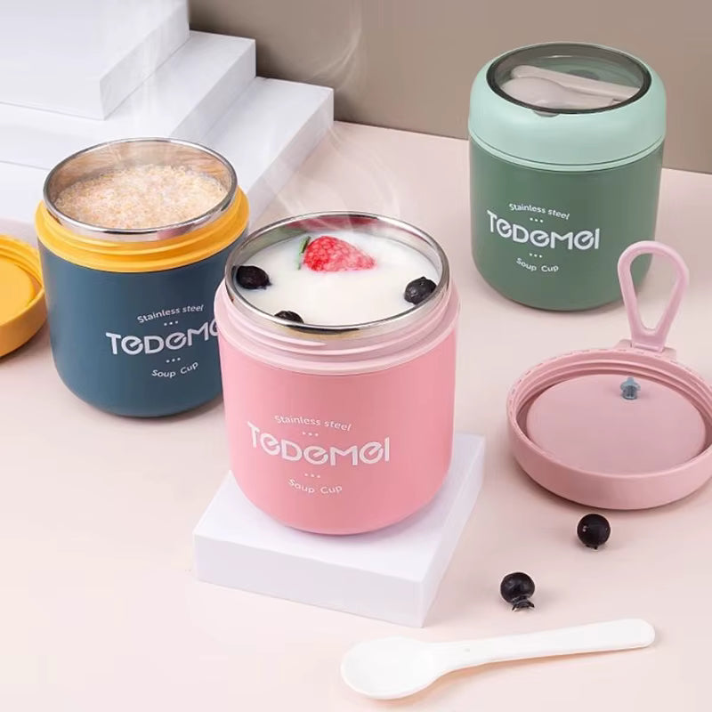 Set of four insulated food containers with colorful lids on a light pink surface.