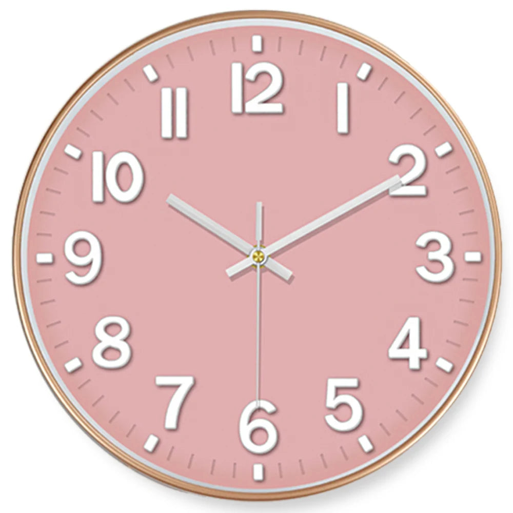 Round wall clock with a pink face and gold frame on a white background