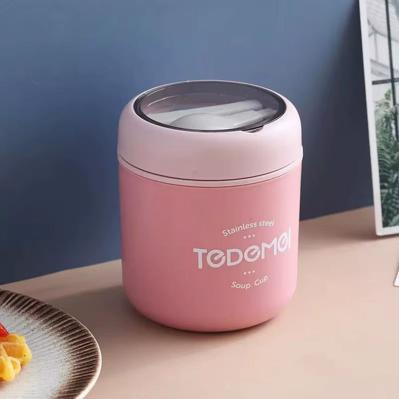 Pink thermos with 'TODEMO' branding on a wooden surface.