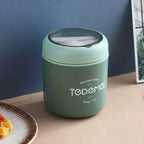 Green thermos container with 'TODEMOI' branding on a table.