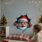 A child sits beside a bed in a decorated bedroom, looking at a large wall decal showing Santa Claus peeking through a torn hole. The room has a light blue wall with string lights, white snowflake decorations, a small Christmas tree, and red-and-white plaid bedding.
