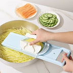 Person using a vegetable chopper to slice vegetables on a kitchen counter.