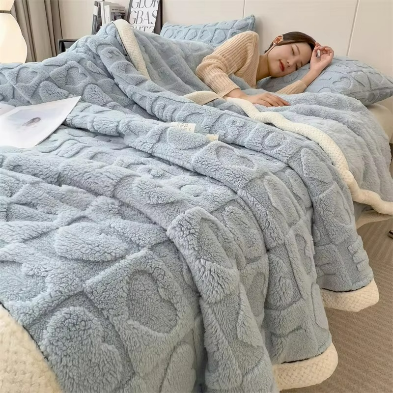 Person lying on a bed covered with a textured blue blanket
