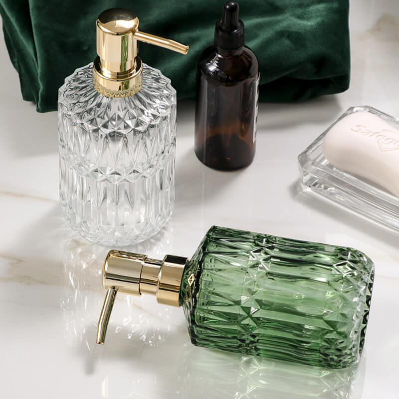 Set of decorative bottles with gold dispensers on a marble surface