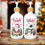Two Christmas-themed soap bottles on a wooden surface with a blurred festive background.