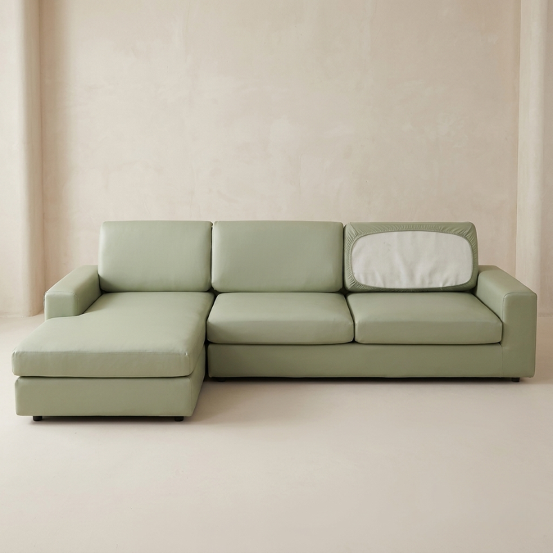 Green sectional sofa against a beige wall