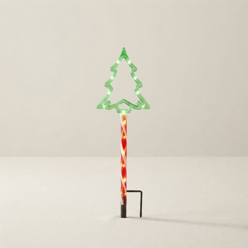 A Christmas tree-shaped outdoor light with a red and white striped pole and a black ground stake, shown against a plain light gray background.