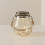 Glass jar with solar light on a plain background