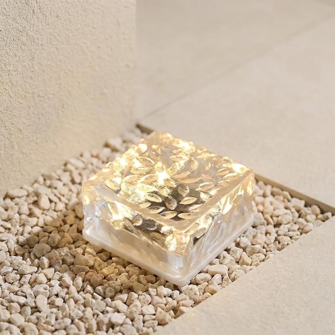 Square LED light embedded in pebbles on a neutral background