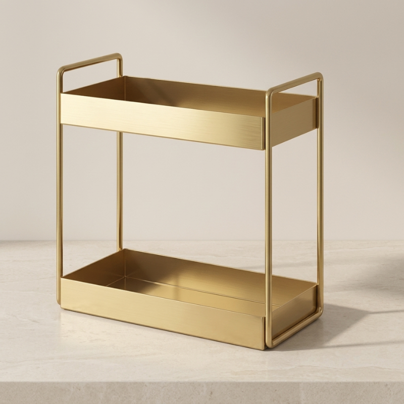 A two-tier gold metal rolling cart with integrated handles and open sides, shown on a light stone surface against a neutral beige background.