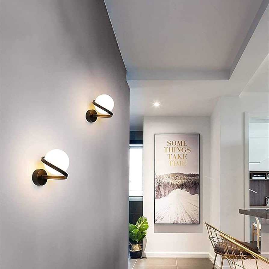 Modern wall sconces on a gray wall with a framed quote in the background.