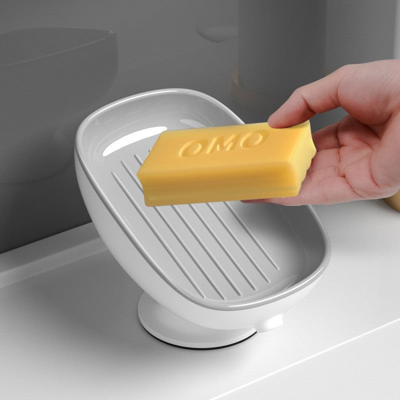 Hand placing a yellow bar of soap into a white soap dish on a bathroom counter.