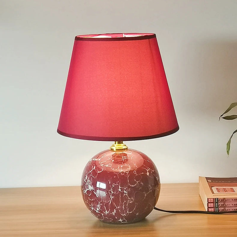 Table lamp with a red shade on a wooden surface
