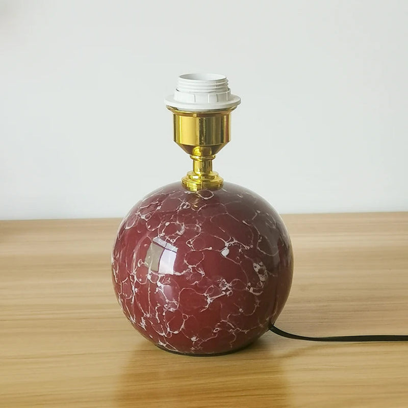 Marble-patterned table lamp on a wooden surface with a white background