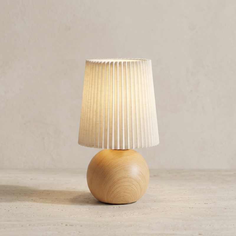 Wooden table lamp with pleated beige shade on a neutral background
