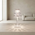 Modern table lamp with a clear glass shade in a minimalistic room.