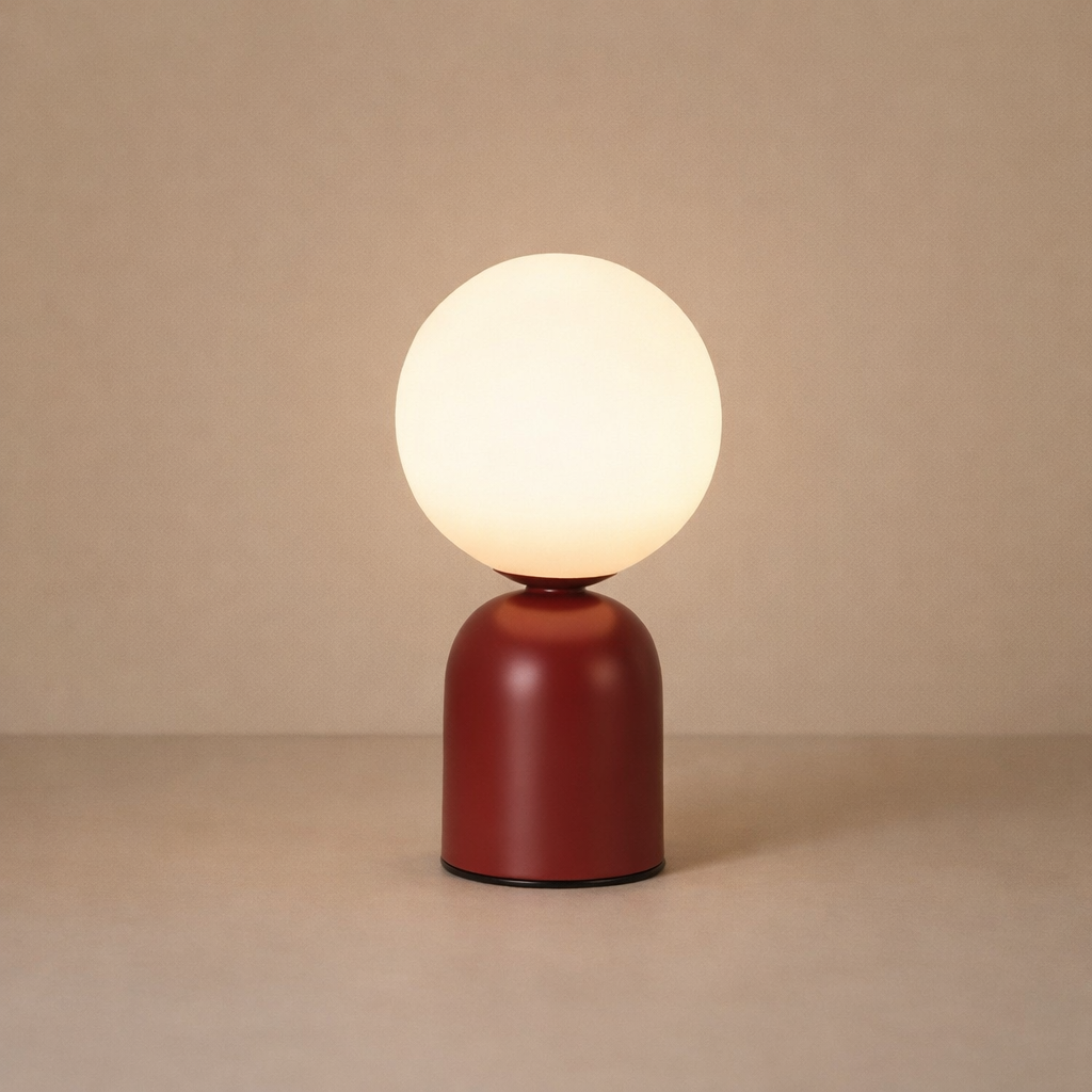 Table lamp with a round white bulb and red base on a beige background