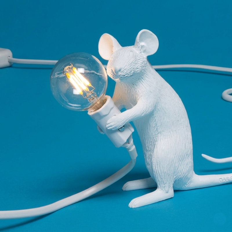 White mouse-shaped lamp holding a light bulb on a blue background