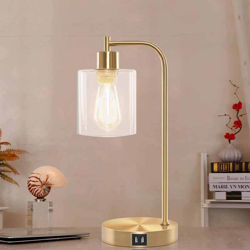 Gold table lamp with a glass shade on a desk