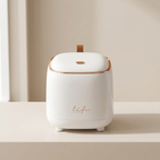 White humidifier with gold accents on a beige surface