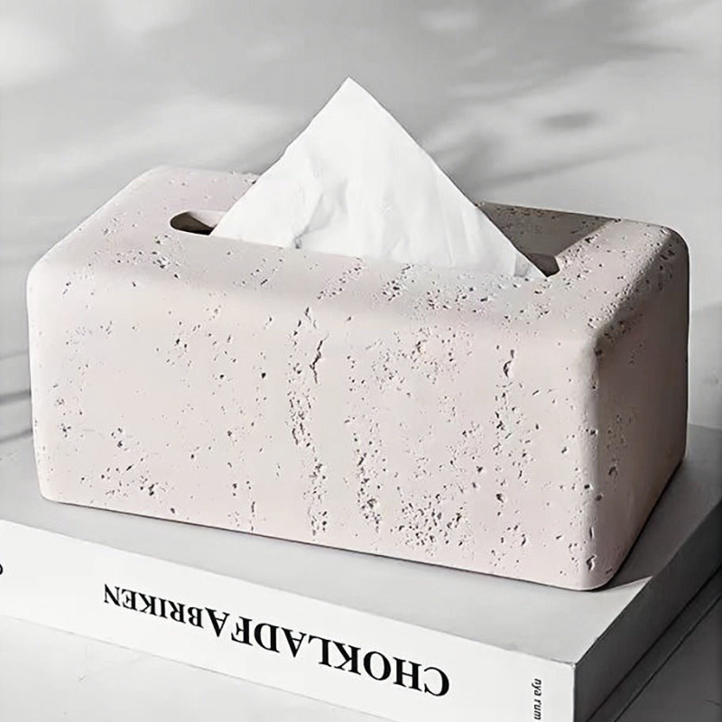 Concrete tissue box holder with tissues on a book