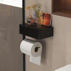 A black floating toilet paper shelf mounted on a beige bathroom wall, holding a roll of toilet paper and decorative vases.