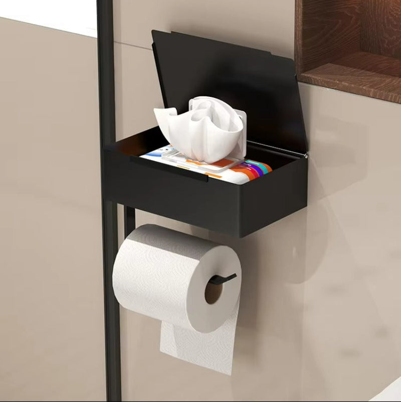 Black metal wall-mounted toilet paper holder with a storage compartment and a hanging toilet paper roll, shown installed on a bathroom wall with text describing its storage capacity.