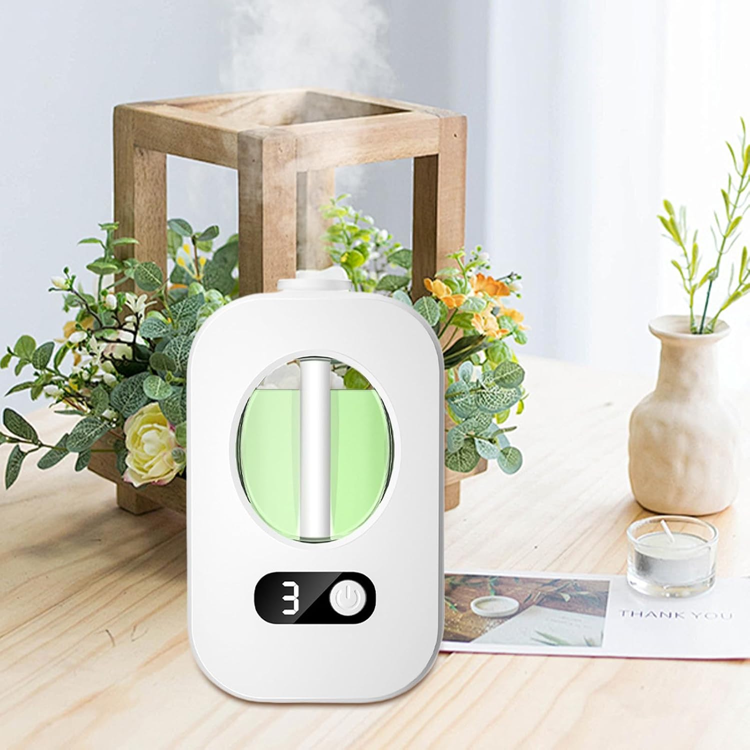 White electronic device with digital display on a wooden surface with plants and a candle.