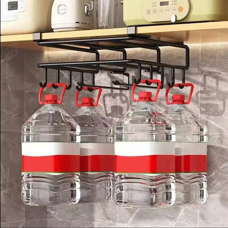 A black metal kitchen water jug rack hanging under a shelf, holding four large clear plastic water bottles with red-and-white labels.