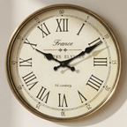 Vintage-style wall clock with Roman numerals and 'France' text on a plain background