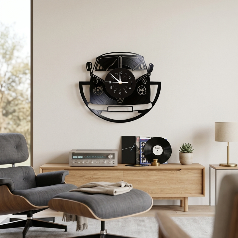 A black wall clock shaped like a classic Volkswagen camper van, mounted on a light beige wall in a modern living room setting.