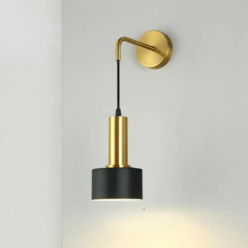 Wall-mounted lamp with gold arm and black shade on a light gray background