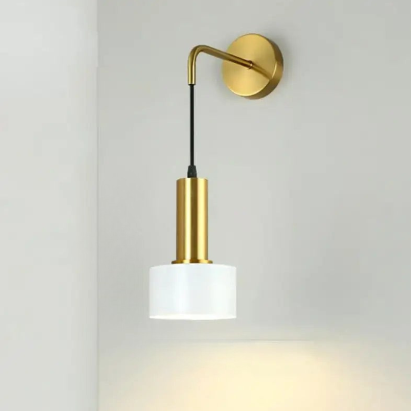 Wall-mounted lamp with gold arm and white shade on a light gray background